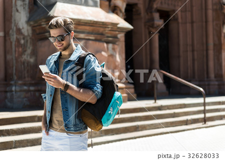 Happy youthful man with beard using gadget while Happy youthful man with beard using gadget while 32628033