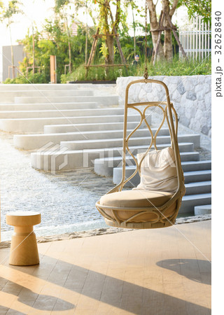 Wicker hanging chair swing hanging on a chain. Wicker hanging chair swing hanging on a chain. 32628840