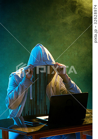 Hooded computer hacker stealing information with Hooded computer hacker stealing information with 32628974