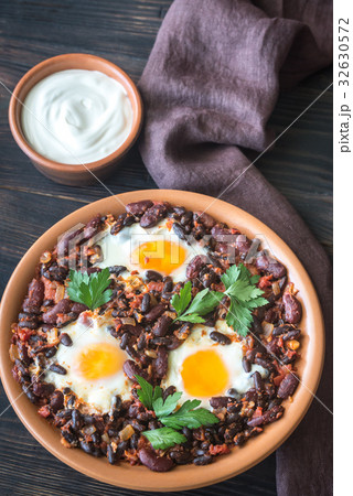 Bowl of chipotle bean chili with baked eggs 32630572