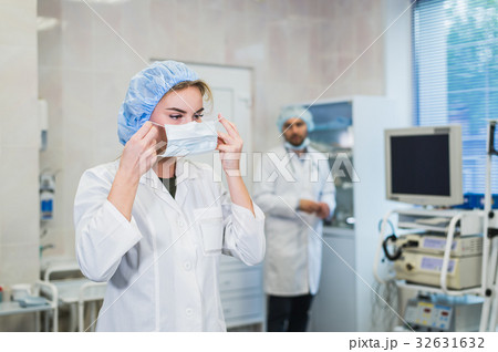 Confident female doctor putting on medical face 32631632