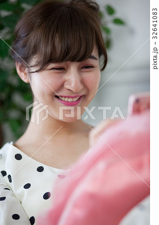 ソファーでスマホを使う若い女性 32641083