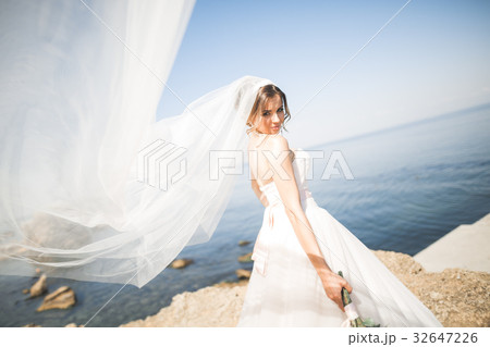 Beautiful young bride with bridal bouquet posing 32647226
