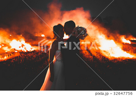 Amazing wedding couple near the fire at night Amazing wedding couple near the fire at night 32647756