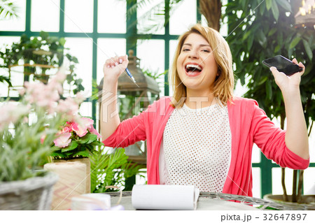 Laughing flower seller with phone 32647897