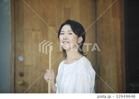 玄関先を掃除する女性 32649646