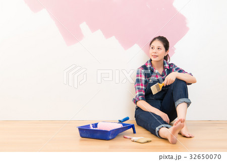 happy smiling woman painting interior in pink happy smiling woman painting interior in pink 32650070