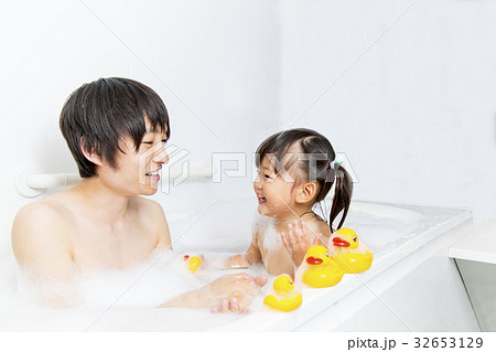 お父さんと一緒にお風呂に入る幼い女の子の写真素材