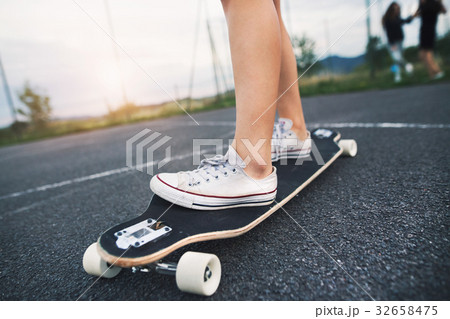 Unrecognizable teenage girl on skateboard outdoors 32658475