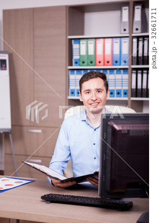 Businessman in office with a folder in hands Businessman in office with a folder in hands 32661711