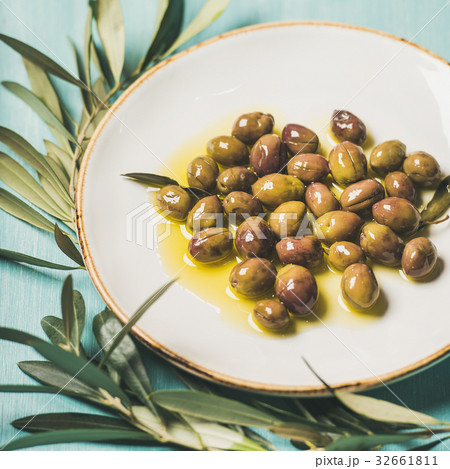 Pickled olives in oil and olive-tree branch over Pickled olives in oil and olive-tree branch over 32661811