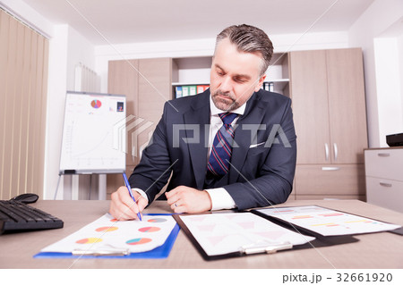 Businessman working on the charts in his office 32661920