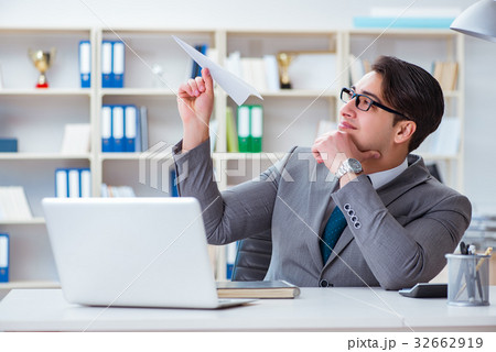 Businessman with paper airplane in office Businessman with paper airplane in office 32662919