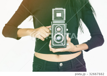 Woman standing and holding camera Woman standing and holding camera 32667882