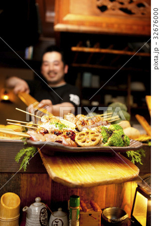 串盛りを差し出す店員 32676000