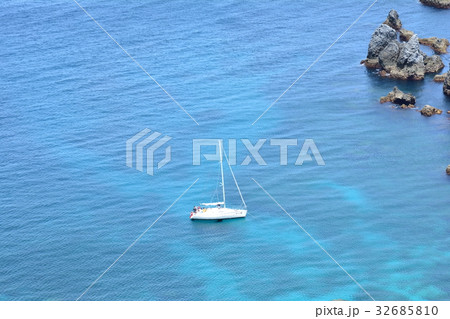 静かな水面に浮かぶヨットを大きな岩 静かな水面に浮かぶヨットを大きな岩 32685810