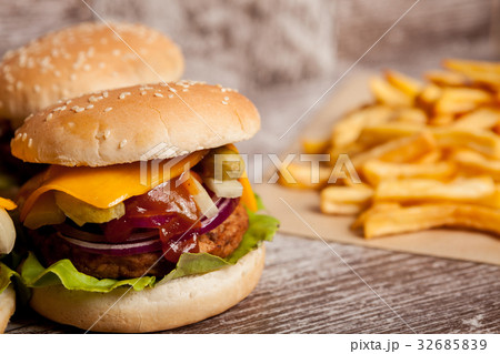 Home made cheeseburgers on wooden plate Home made cheeseburgers on wooden plate 32685839
