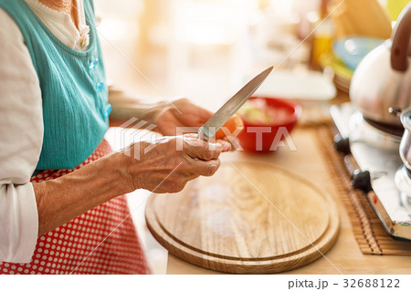 Senior woman hands chopping vegetables on a wooden 32688122
