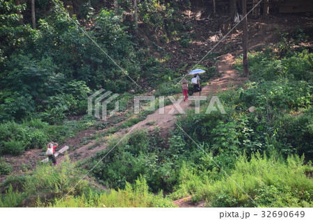 ラオス ノンキャウからムアンクアへの船の旅 船内からの眺め 山道を歩く家族 ラオス ノンキャウからムアンクアへの船の旅 船内からの眺め 山道を歩く家族 32690649