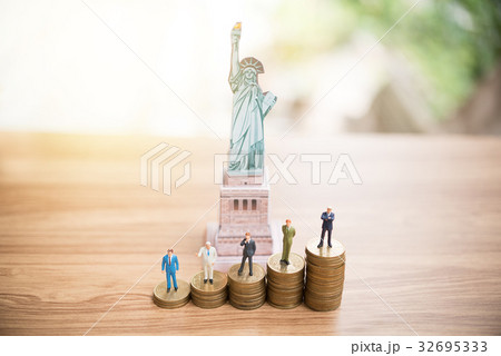Miniature people standing on coin 32695333