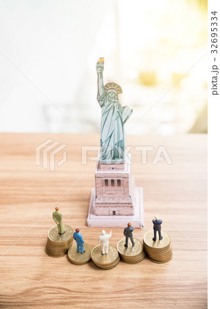 Miniature people standing on coin  32695334