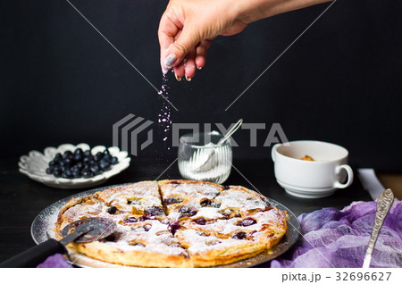 Female adding sugar to a sweet pie 32696627