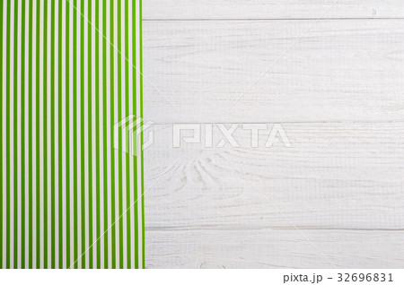 Green stripes tablecloth on wooden table Green stripes tablecloth on wooden table 32696831