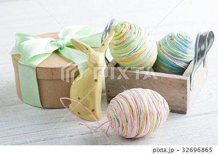 Easter composition with gift, toy rabbit and eggs 32696865