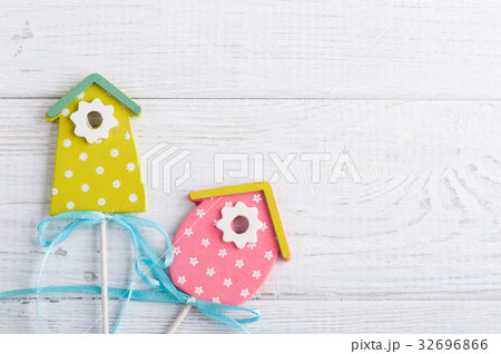 Green pink birdhouses on the white wooden  32696866