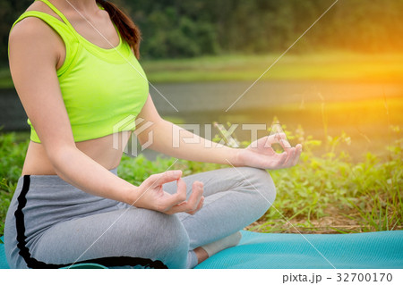 young woman sitting Yoga near river. Concept of young woman sitting Yoga near river. Concept of 32700170