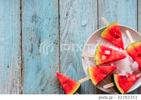 Watermelon slice popsicles on a blue rustic wood  32702351