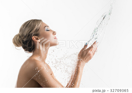 Pretty girl catching water stream in her hands Pretty girl catching water stream in her hands 32709365