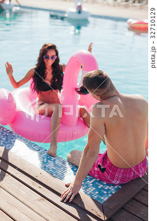 Girl in pool talking to man in the summer Girl in pool talking to man in the summer 32710129