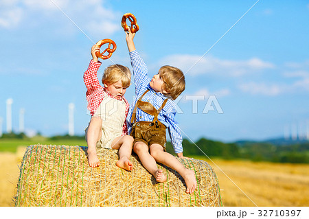 Two little kid boys, twins and siblings sitting on 32710397
