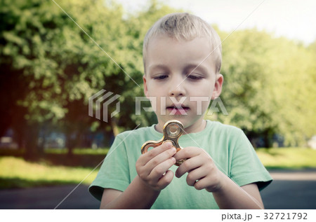 Little boy with a fidget spinner outdoors 32721792