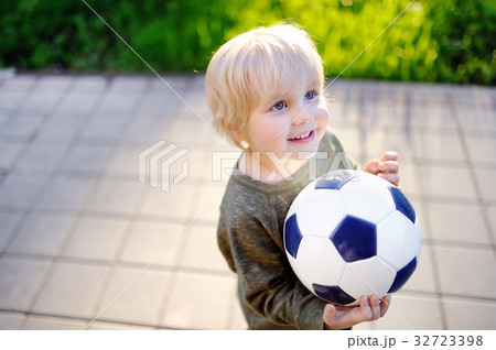 Little boy having fun playing a soccer game  32723398