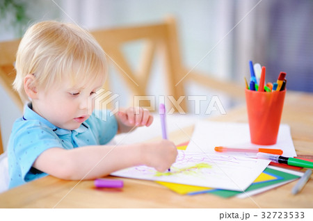 Cute little boy drawing and painting with colorful markers pens at kindergarten 32723533