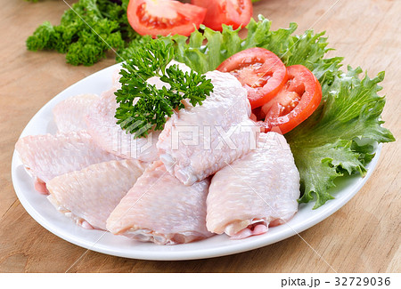 Raw chicken wings with vegetables on wooden board 32729036