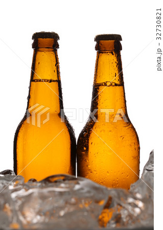 Two bottles of cider in ice cubes. Close up. White Two bottles of cider in ice cubes. Close up. White 32730821