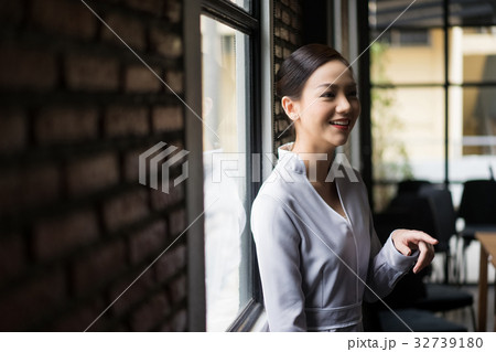 A woman is talking with someone and smiling A woman is talking with someone and smiling 32739180