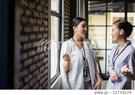 two business women are discussing near by the window two business women are discussing near by the window 32739224