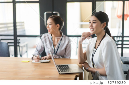 a photo of two happy business women listening something in meeting room 32739280