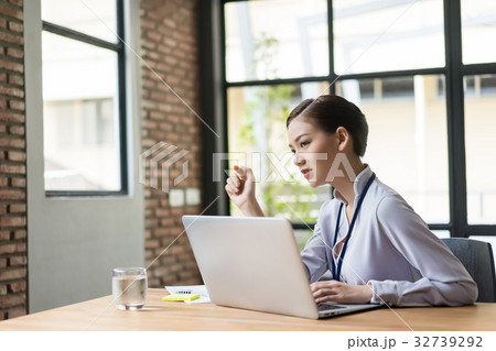 Business woman is sitting and thinking seriously in her office Business woman is sitting and thinking seriously in her office 32739292