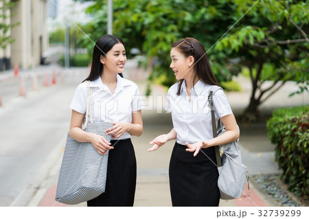 Two university students are chatting together on the sidewalk Two university students are chatting together on the sidewalk 32739299