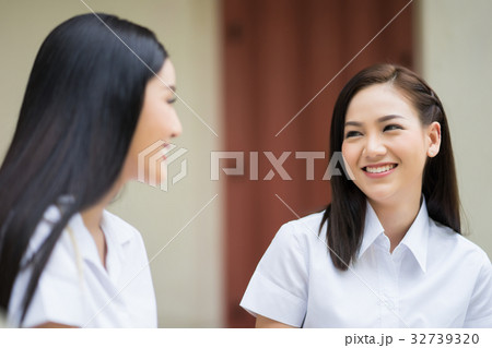 two young girls are looking at each other and smiling two young girls are looking at each other and smiling 32739320