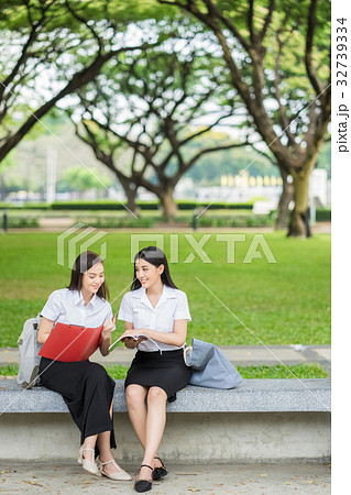 two female students are sitting and discussing on campus 32739334