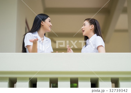 two female students are talking on a balcony 32739342