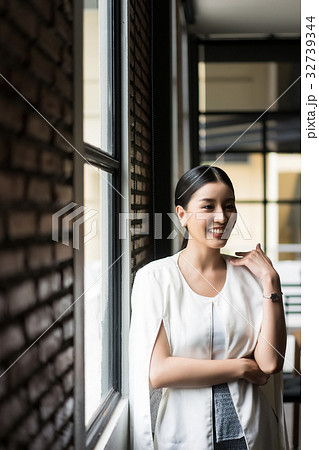 a business woman is standing and smiling with someone a business woman is standing and smiling with someone 32739344
