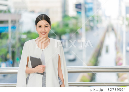 The portrait of woman standing and holding the tablet 32739394