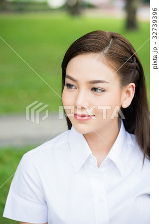 a portrait of a young girl in white shirt smiling 32739396